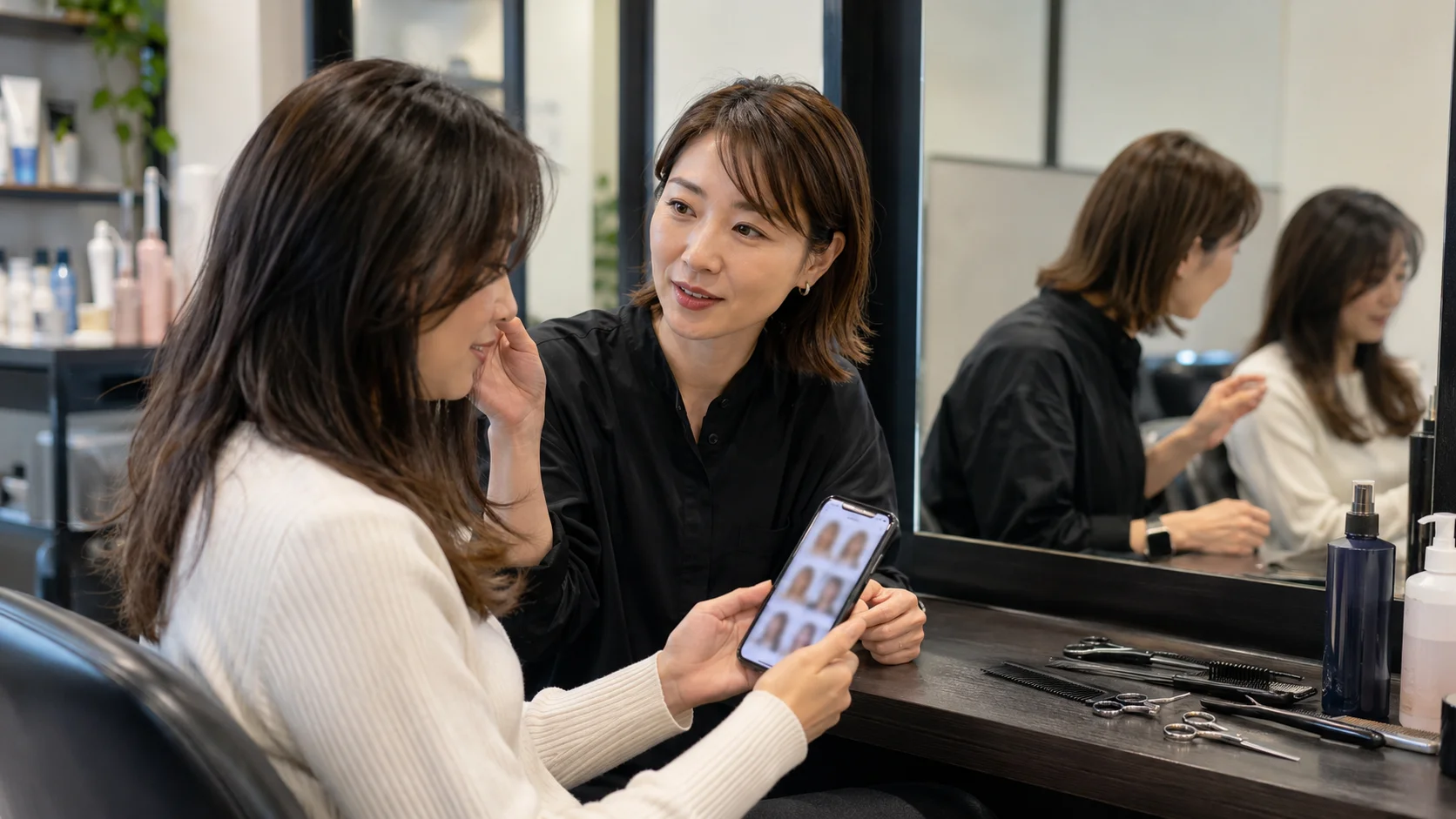 ヘアサロンで参考写真を見せながら相談する様子